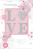 An air of gentle celebration surrounds this anniversary card, which combines a romantic colour palette with delicate detail, perfect for couples in Grove Park wanting something softly sentimental. The central focus is the raised word LOVE, its letters coated in fine glitter that glimmers in blush pink, pearl, and hints of silver. You can almost feel the texture of the letters, slightly rough yet refined, as if dusted with tiny crystals. This word sits on a rectangular panel of warm blush pink, providing a serene anchor to the design. From around this centrepiece, a cascade of illustrated flowers and swirling stems unfurls across the card. The blooms are stylised, with petals drawn in slender lines of pink and gentle grey, some lightly shaded to create the sense of layered depth you might see in a florist's bouquet laid out on a worktable near Grove Park station. Silver accents discretely trace parts of the petals and curling vines, catching the light without disturbing the pastel softness of the colour scheme. The backdrop is a smooth wash of pale pink, untextured and calm, allowing the raised word and floral tracery to float visually on the surface. Intertwined with the artwork is an anniversary message written in elegant, flowing script, speaking of love that continues day after day. The script, in muted grey, mirrors the card's overall restraint and grace. Together, the raised lettering, glitter highlights, and gentle florals create a keepsake that feels like a quiet bouquet in paper form, ideal for honouring an anniversary in the peaceful surroundings of Grove Park.